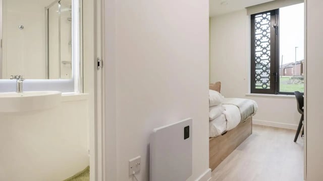 Bed with white linens and desk area bedroom at St Gabriels in Manchester Student Accommodation
