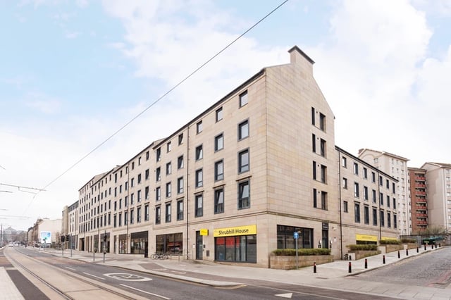 Stone building with storefronts and tram lines exterior at Shrubhill House in Edinburgh Student Accommodation