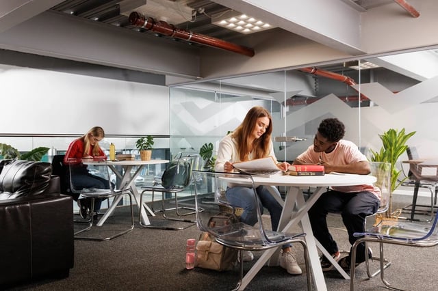 Students studying at tables lounge area at Shrubhill House in Edinburgh Student Accommodation