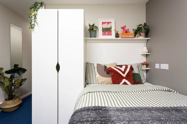 Wardrobe bed with striped bedding and decorative pillows bedroom at Murano House in Edinburgh Student Accommodation