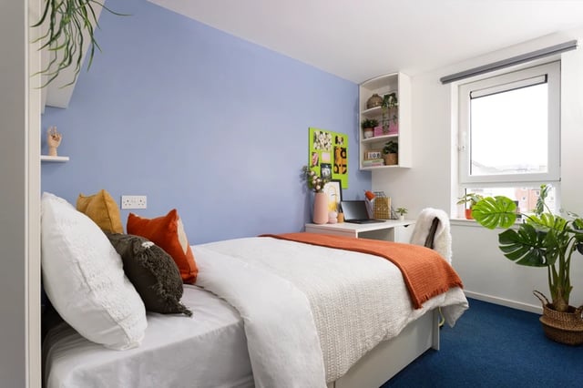 Bed with colorful pillows desk and window bedroom at Murano House in Edinburgh Student Accommodation