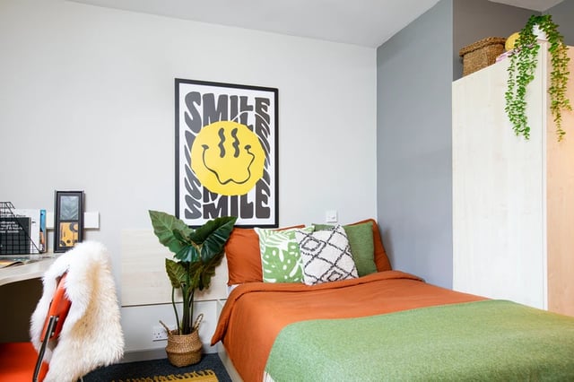 Bed with orange bedding and patterned pillows bedroom at Blackfriars in Glasgow Student Accommodation