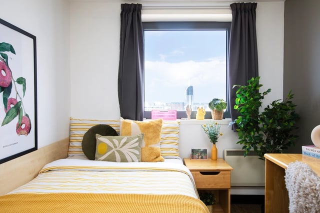 Bed with yellow bedding and pillows window study area at Trafalgar Hall in Portsmouth Student Accommodation