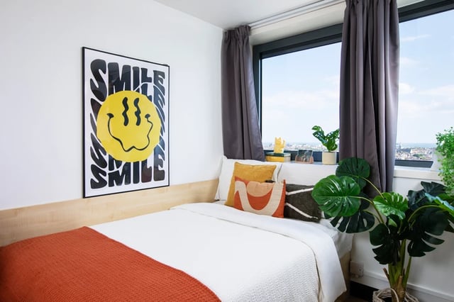 Bed with smile poster and plants bedroom at Trafalgar Hall in Portsmouth Student Accommodation