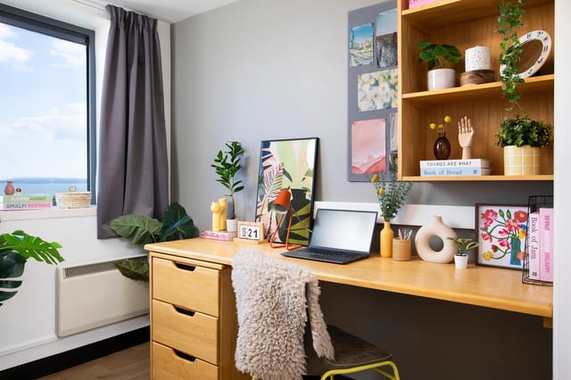 Desk with laptop artwork plants and books study area at Trafalgar Hall in Portsmouth Student Accommodation