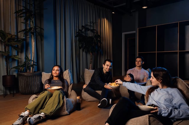 Four friends relaxing in beanbag chairs living area at Arch View House in London Student Accommodation