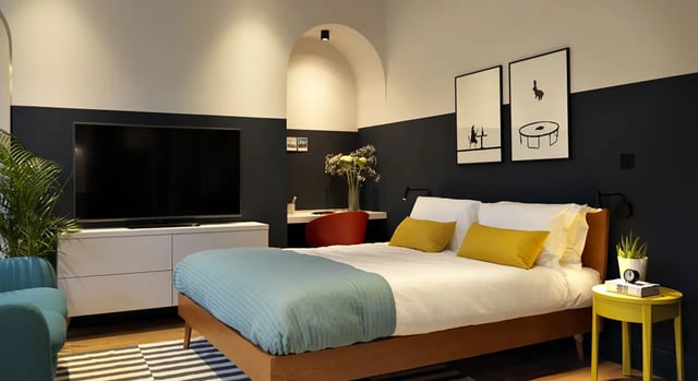Bed TV desk plant and armchair bedroom at Student Castle Bath in Bath Student Accommodation
