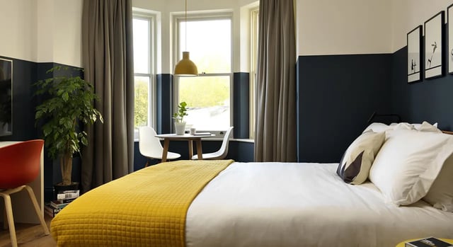Bed with yellow blanket desk plant dining table Bedroom at Student Castle Bath in Bath Student Accommodation