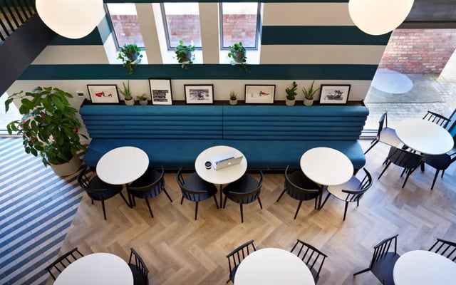 Tables chairs blue bench and plants communal area at Student Castle Durham in Durham Student Accommodation