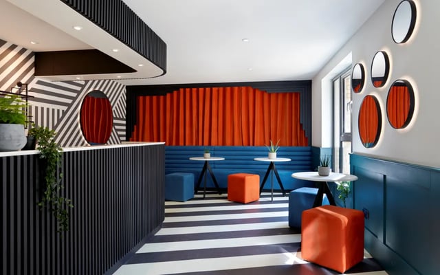 Reception area with blue seating orange accents living area at Student Castle Durham in Durham Student Accommodation