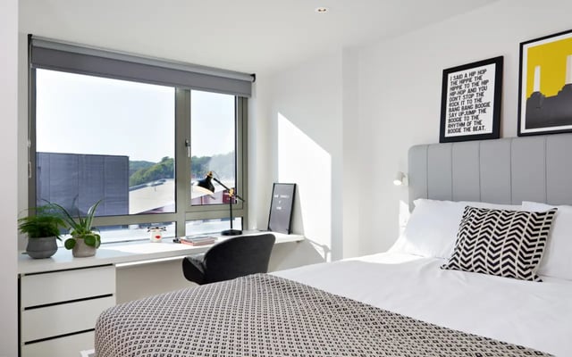 Bed with patterned throw desk and window Bedroom at Student Castle Durham in Durham Student Accommodation