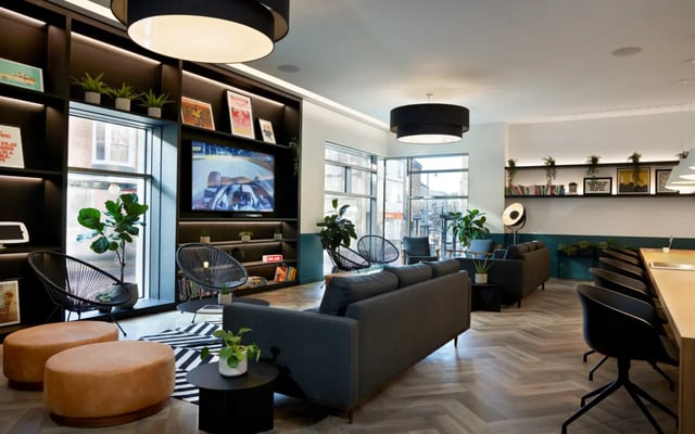 Sofas chairs television plants and artwork common area at Student Castle Durham in Durham Student Accommodation