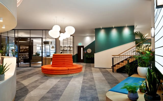Orange circular sofa and staircase in lobby living room at Student Castle Durham in Durham Student Accommodation