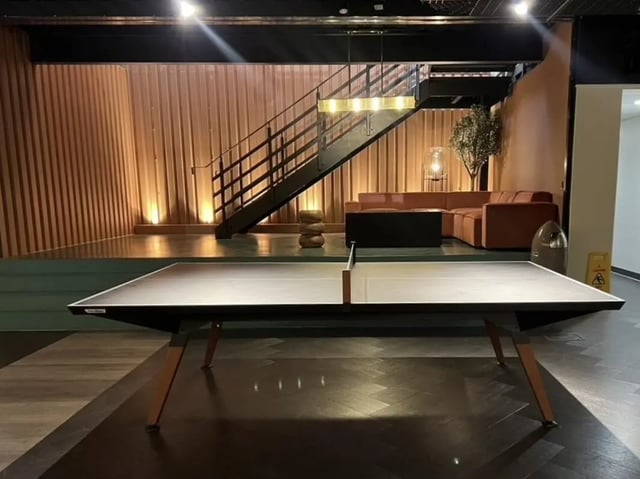 Ping pong table lounge area with stairs and sofa. at Student Castle Reading (New Century Place) in Reading Student Accommodation
