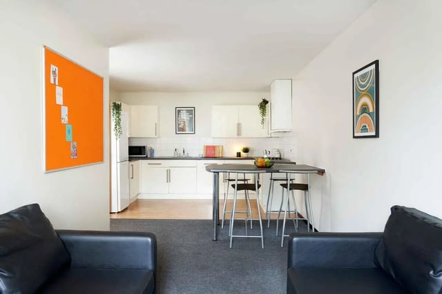 Black sofas orange board kitchen bar area living room at Transom House in Bristol Student Accommodation
