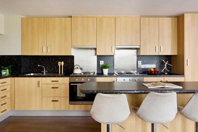 Kitchen with light wood cabinets stovetop sink and stools Kitchen at Millennium View in Coventry Student Accommodation