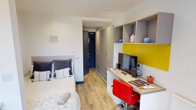 Bed desk TV wardrobe and shelves bedroom at Opto village in Luton Student Accommodation