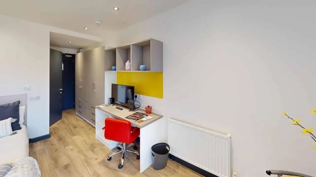 Wardrobe desk bed red chair bedroom at Opto village in Luton Student Accommodation
