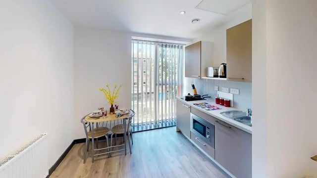 Kitchenette with dining table and microwave kitchen at Opto village in Luton Student Accommodation