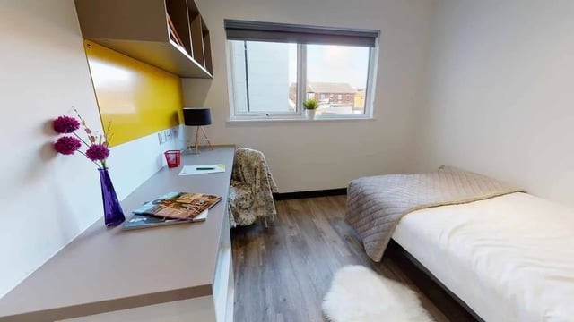 Bed desk flowers and shelves student room at Opto village in Luton Student Accommodation
