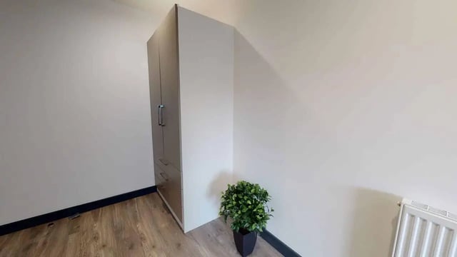 Wardrobe and plant in empty room bedroom at Opto village in Luton Student Accommodation