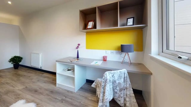 Desk shelving lamp and chair study area at Opto village in Luton Student Accommodation