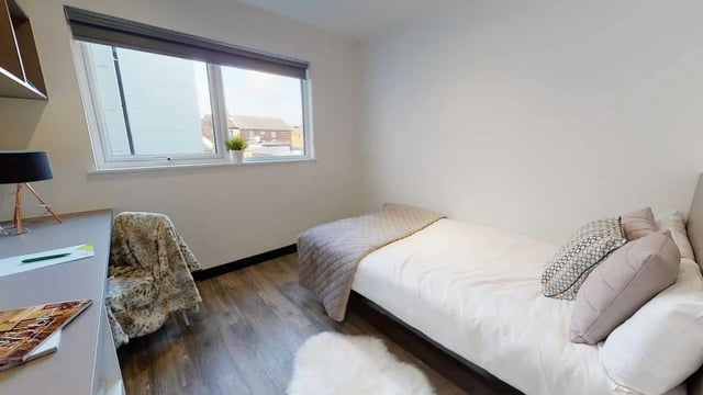 Desk bed chair window fluffy rug bedroom at Opto village in Luton Student Accommodation