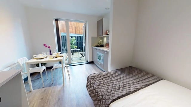 Bed dining table kitchen area and patio studio apartment at Opto village in Luton Student Accommodation