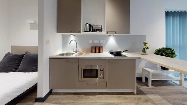 Studio apartment with bed and kitchen area at Opto village in Luton Student Accommodation