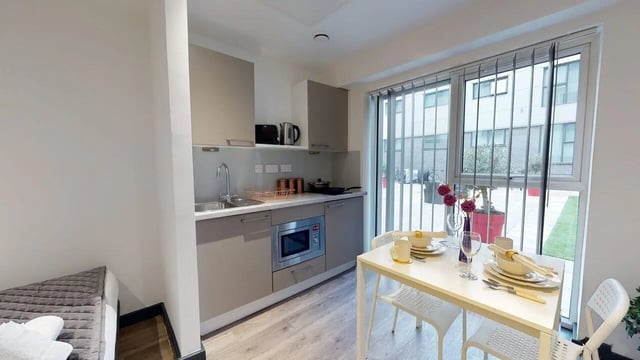 Kitchen area with dining table and window at Opto village in Luton Student Accommodation