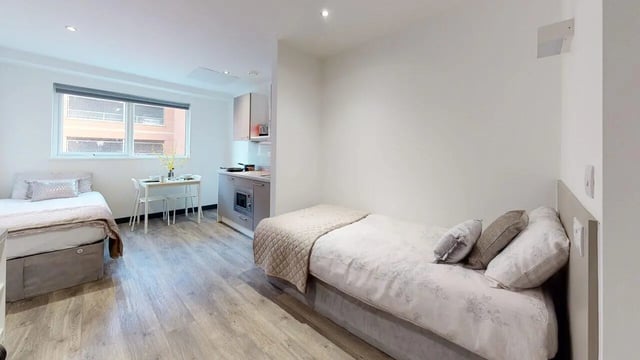 Two beds table kitchen area living room at Opto village in Luton Student Accommodation