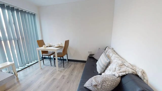 Dining table couch with pillows living room at Opto village in Luton Student Accommodation