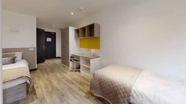 Two beds desk wardrobe and door bedroom at Opto village in Luton Student Accommodation