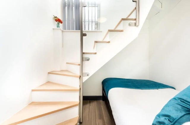Wooden stairs and bed with teal bedding bedroom at Chapel Street - Luton in Luton Student Accommodation