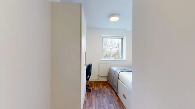 Wardrobe chair bed and window bedroom at Park House in Luton Student Accommodation