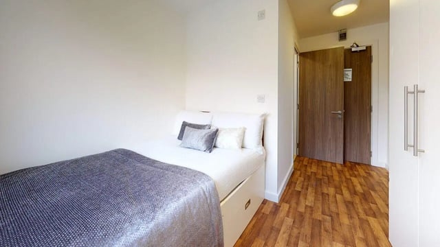 Bed with pillows drawers and doors bedroom at Park House in Luton Student Accommodation