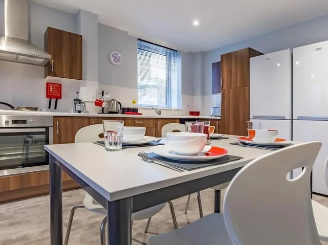 Table with place settings and kitchen appliances kitchen at Mary Parker House in Plymouth Student Accommodation