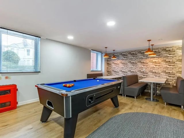 Pool table with balls and seating area Playing area at Mary Parker House in Plymouth Student Accommodation