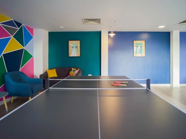 Ping pong table with rackets and seating area recreation room at The Recording Rooms in Birmingham Student Accommodation