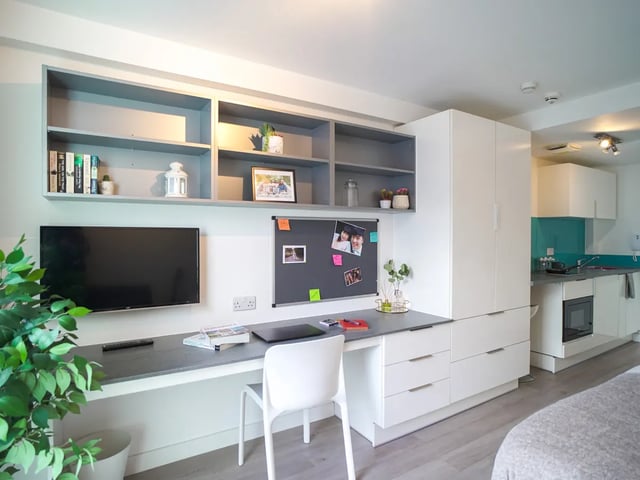 Desk shelves TV kitchen cabinet living room at The Recording Rooms in Birmingham Student Accommodation