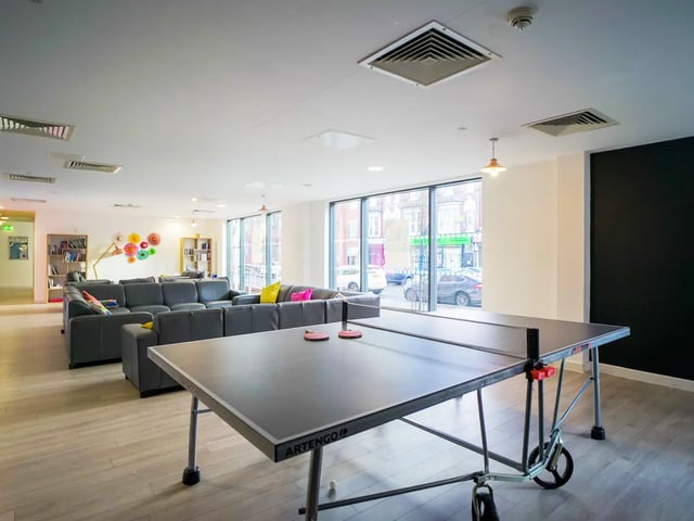 Ping pong table couches bookshelves living room playing area at The Recording Rooms in Birmingham Student Accommodation