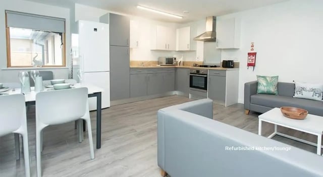 Dining table fridge modern kitchen lounge area at Abode York in York Student Accommodation