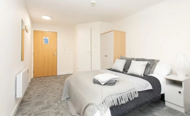 Bed wardrobe closet bedside table bedroom at Abode York in York Student Accommodation