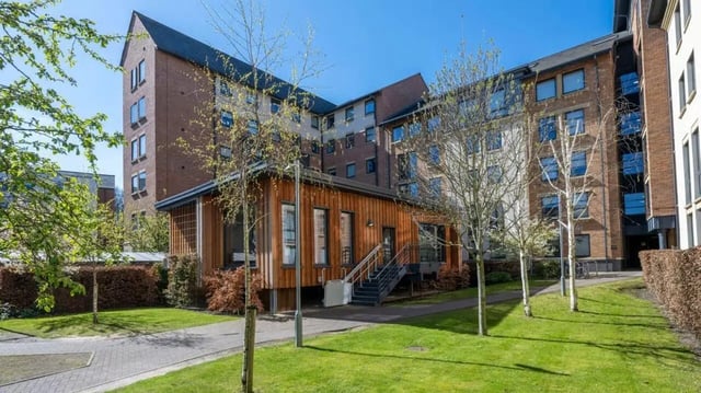 Wooden building with large windows and stairs exterior at Abode York in York Student Accommodation