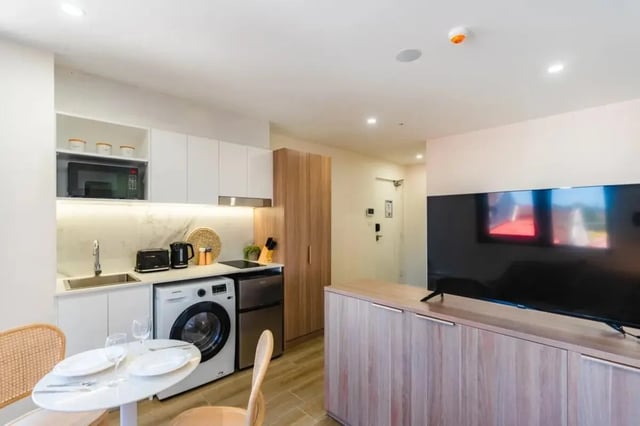 Kitchenette with washing machine television living room at UKO Annandale in Sydney Student Accommodation