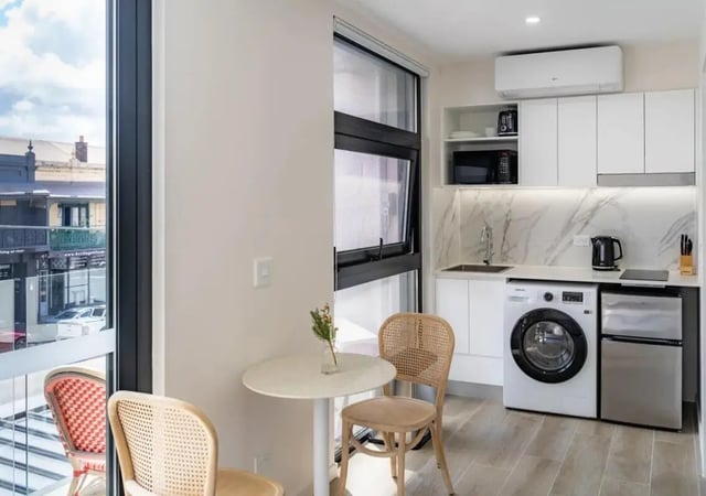Small kitchen area with table chairs and appliances kitchen at UKO Annandale in Sydney Student Accommodation