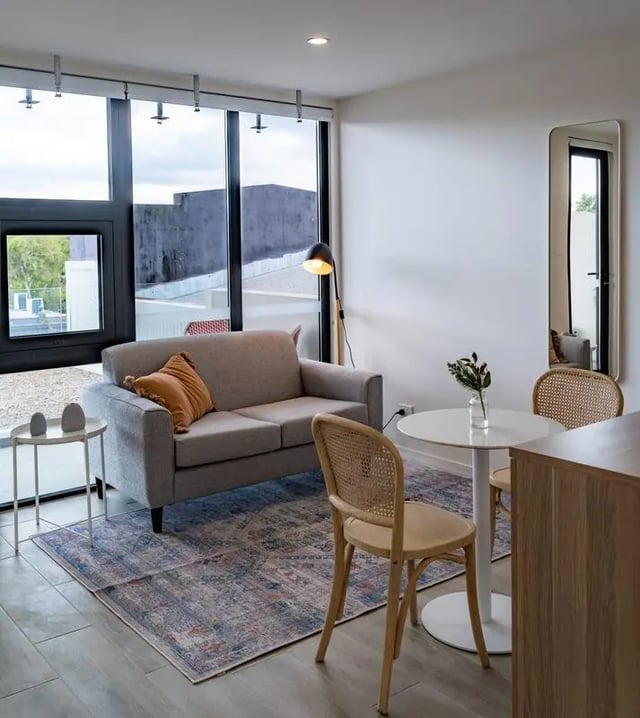 Sofa table chairs rug floor lamp living room at UKO Annandale in Sydney Student Accommodation