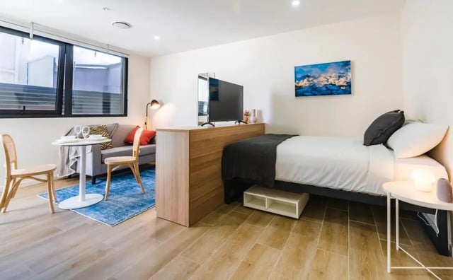 Bed sofa table chairs and TV bedroom living room at UKO Annandale in Sydney Student Accommodation