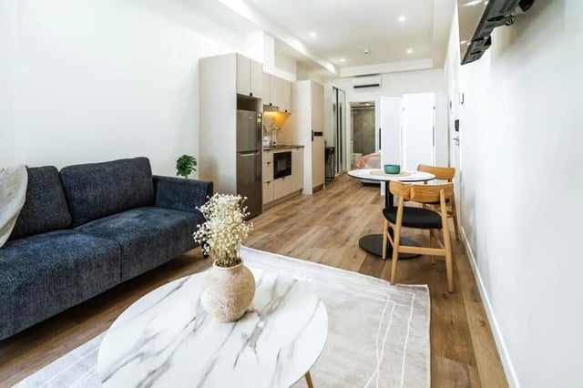 Sofa kitchen table chairs and bed living room at UKO Annandale Tower C in Sydney Student Accommodation