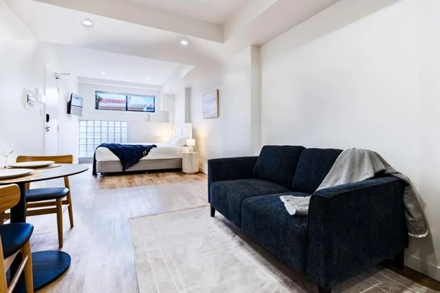 Bed sofa table and chairs living room at UKO Annandale Tower C in Sydney Student Accommodation